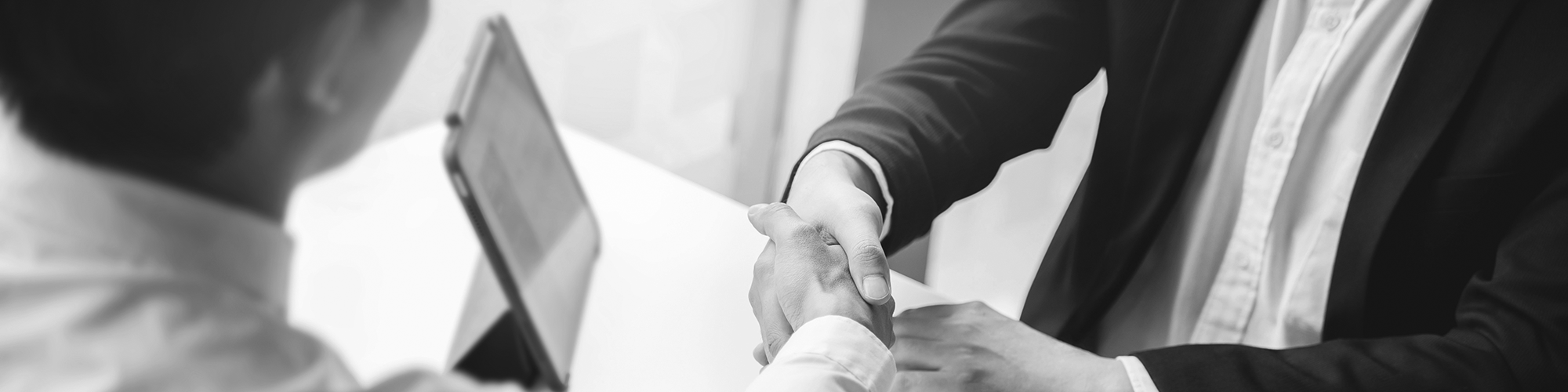 Two people shaking hands in an office setting